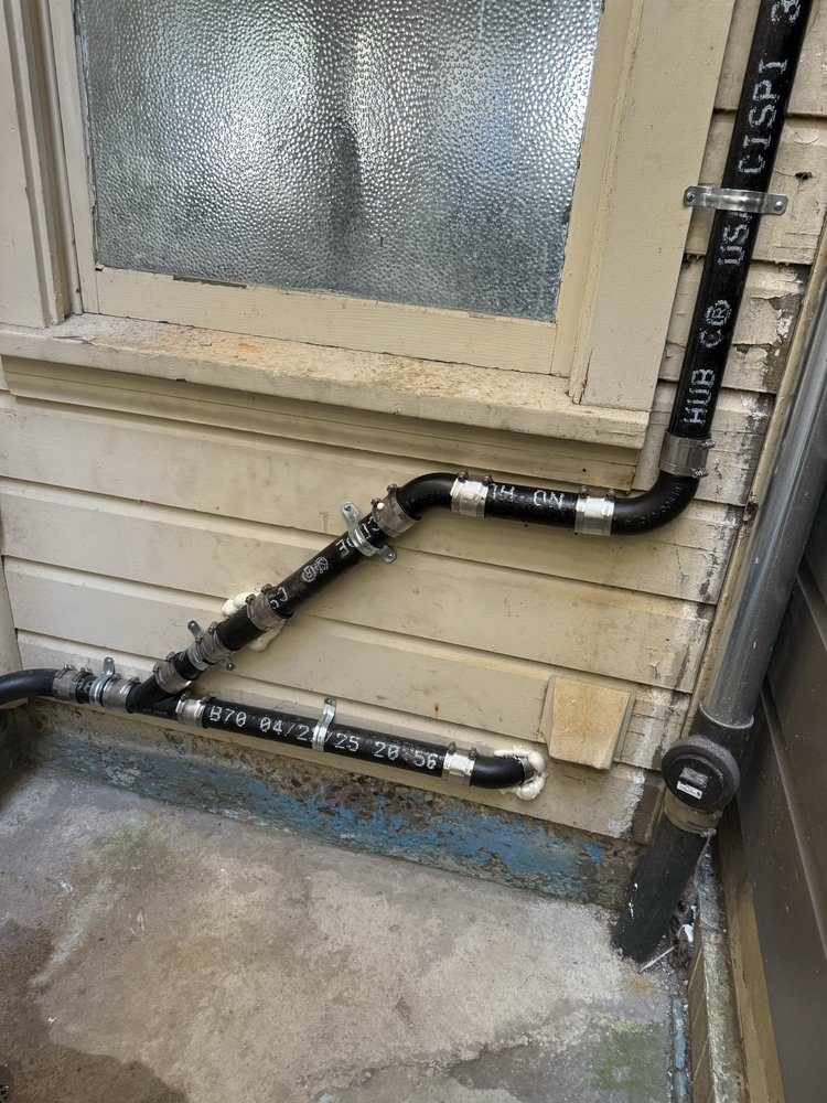 Black iron gas line installation on exterior wall